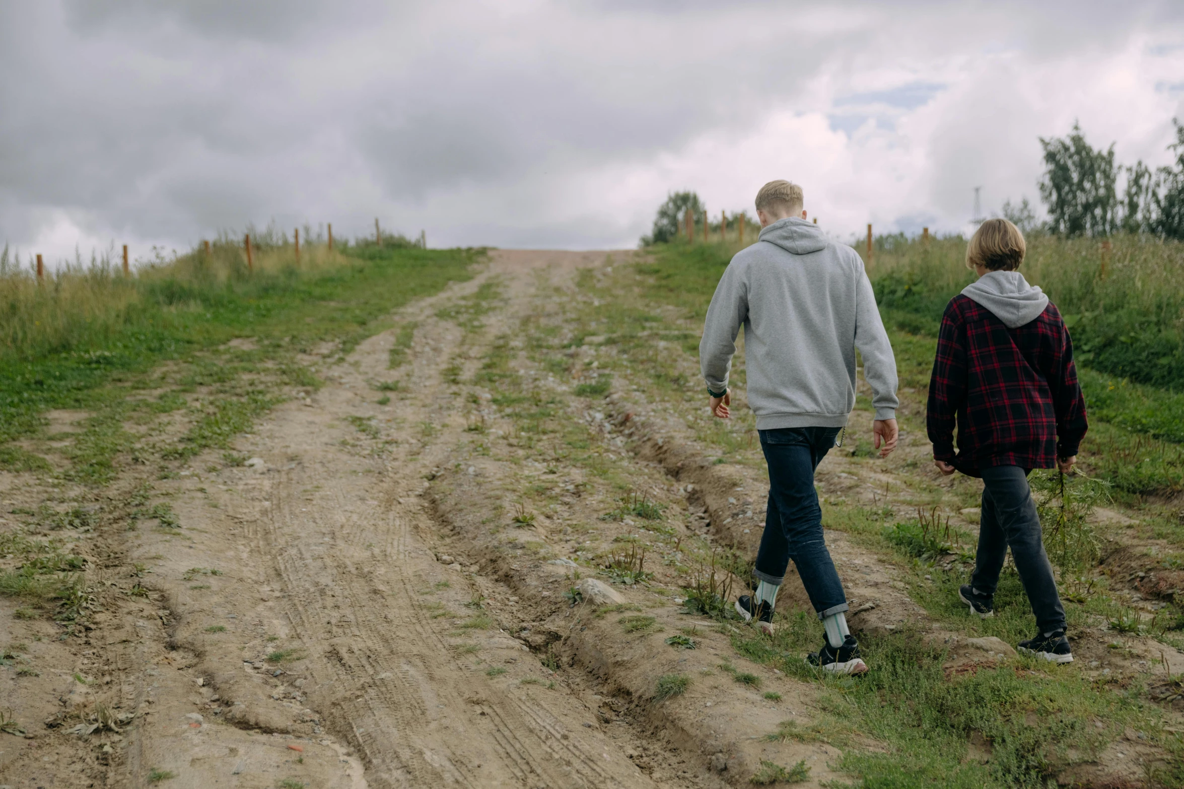 a man and a woman walking down a dirt road, top of the hill, mr beast, alex heywood, stillframe