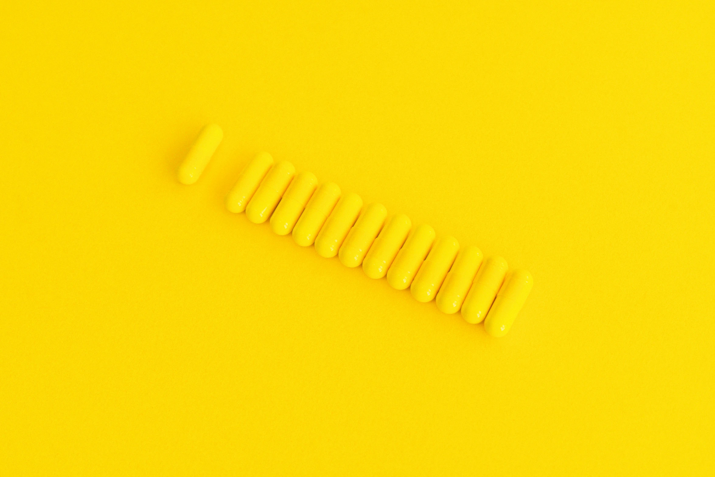 a row of yellow pills on a yellow background, by Pamphilus, trending on pexels, op art, tiny sticks, minimalist abstract art, vibrant threads, instagram post