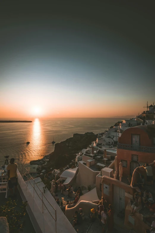 a view of the sun setting over the ocean, by Alexis Grimou, pexels contest winner, santorini, low quality photo, sleepy, casually dressed