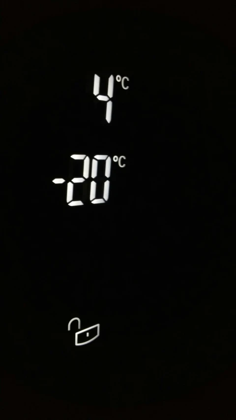 a close up of a digital clock on a wall, by Ian Fairweather, hot temperature, black background!!!!!, snow weather, white on black