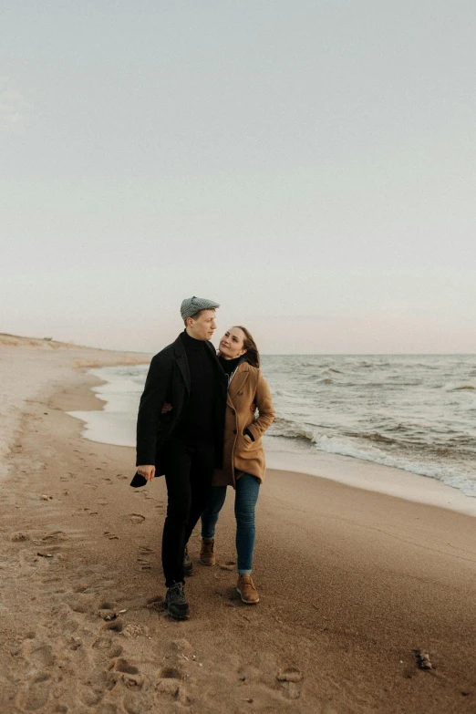 a man and woman standing on a beach next to the ocean, profile image, fall season, 2019 trending photo