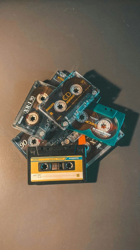 a pile of cassettes sitting on top of a table, by Nina Hamnett, pexels, flat lay, multiple stories, cd, 8 bit