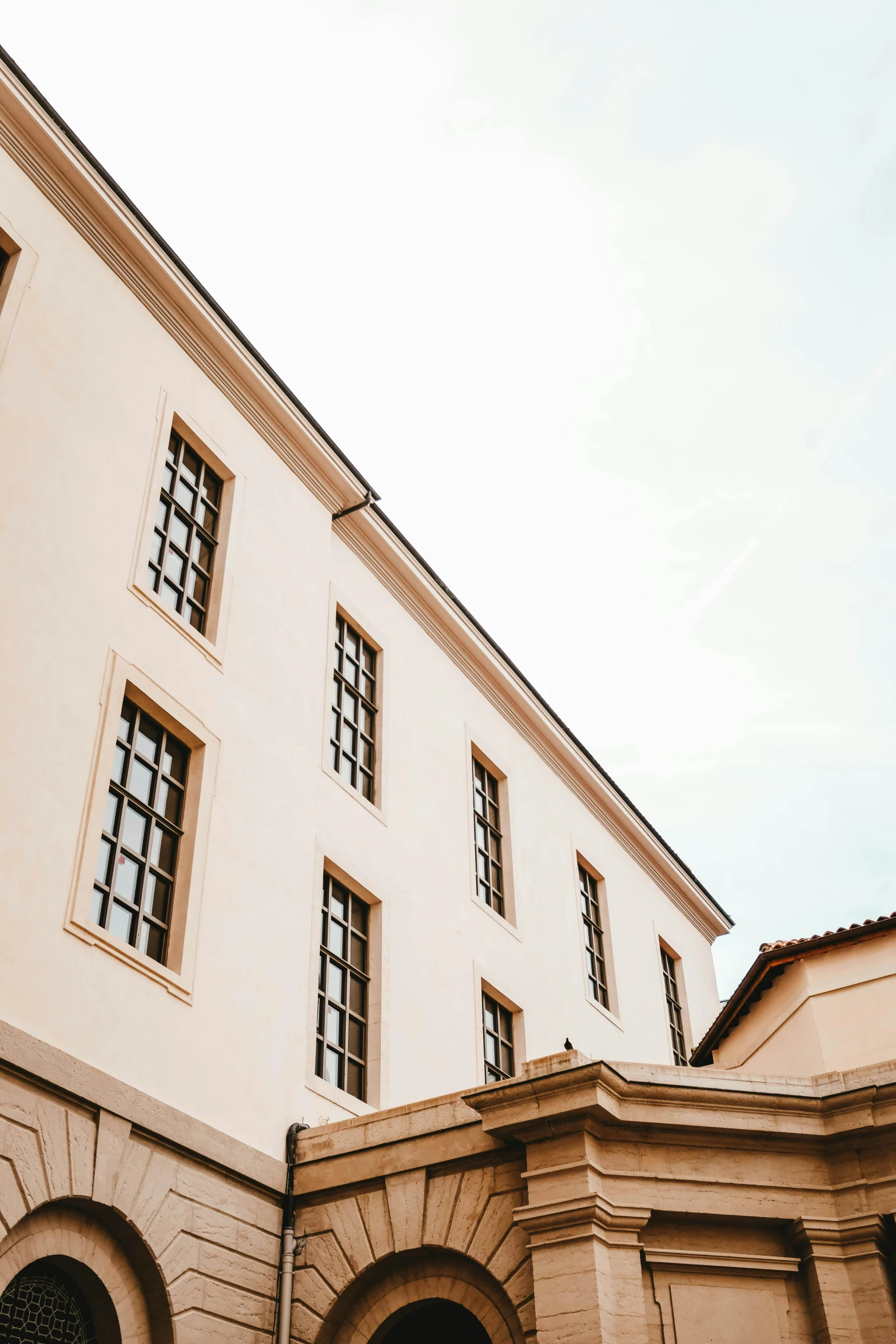 a building with a clock on the front of it, an album cover, inspired by David Chipperfield, trending on pexels, neoclassicism, florentine school, wide windows, looking upwards, white building