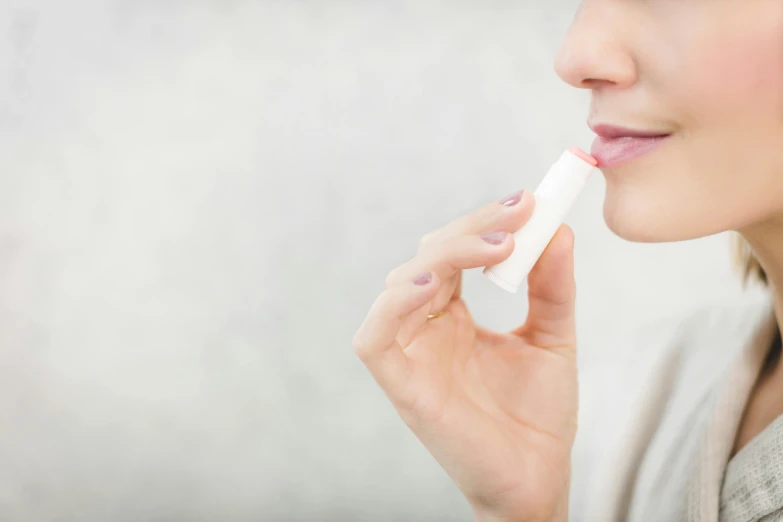 a woman putting a lip bale on her lips, tachisme, fan favorite, manuka, square, istock