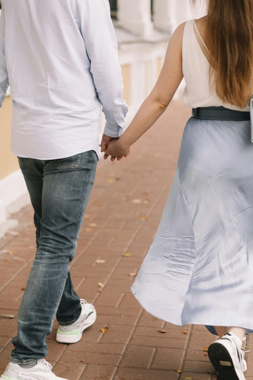 a man and a woman walking down a sidewalk holding hands, trending on unsplash, renaissance, white and pale blue, romantic lead, celebrating an illegal marriage, wearing casual clothing