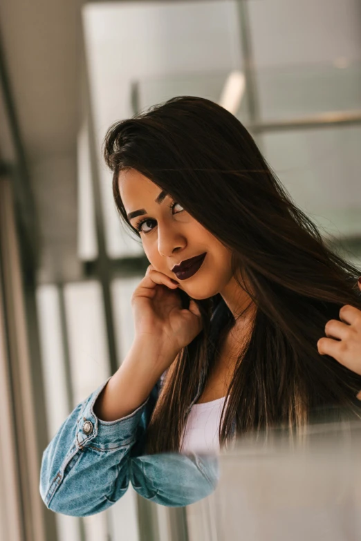 a woman standing in front of a mirror talking on a cell phone, trending on pexels, tachisme, dark brown colored long hair, purple lipstick, headshot profile picture, young middle eastern woman