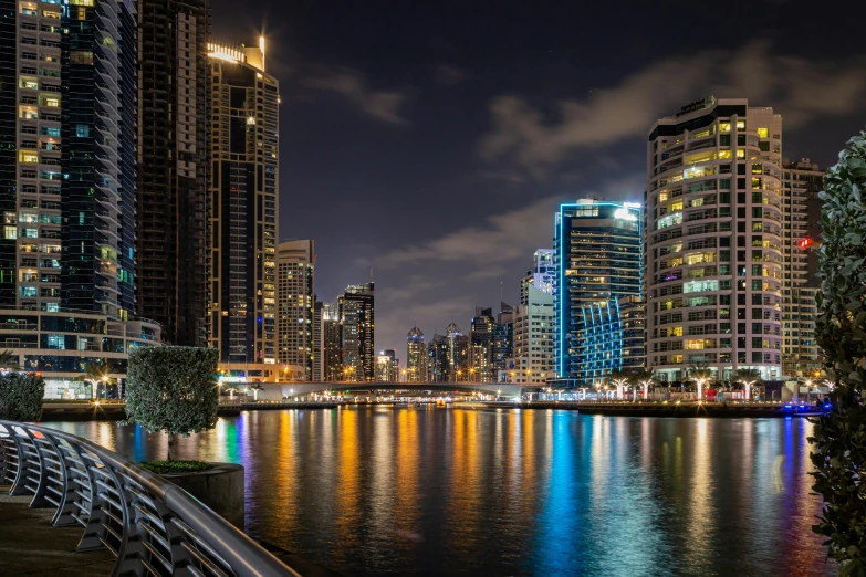 a large body of water surrounded by tall buildings, by Erik Pevernagie, pexels contest winner, hurufiyya, colourful lighting, middle eastern, at the waterside, slide show