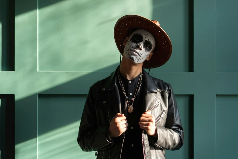 a man wearing a mask and a leather jacket, an album cover, pexels contest winner, sombrero, white facepaint, ( ( ( skeleton ) ) ), background image