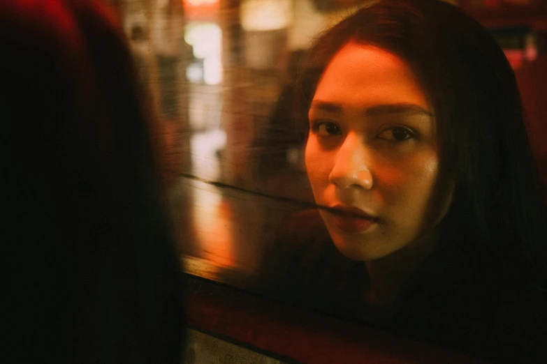 a woman looking at herself in a mirror, pexels contest winner, photorealism, 8 0 s asian neon movie still, man looks out of a train window, film still of gal gadot, late night melancholic photo