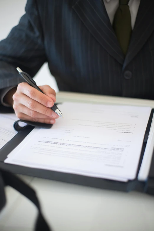 a man in a suit writing on a piece of paper