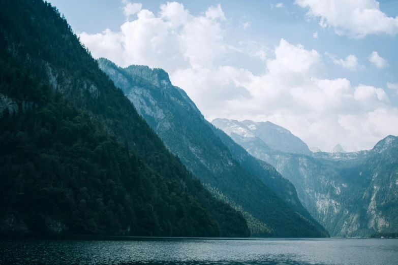 a large body of water surrounded by mountains, pexels contest winner, minimalism, trees and cliffs, thumbnail, multiple stories, 8k cinematic shot