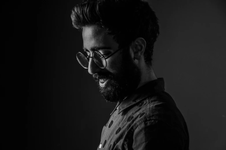 a black and white photo of a man with a beard, by Giorgio Cavallon, pexels contest winner, a portrait of rahul kohli, wearing black glasses, shot at dark with studio lights, profile picture