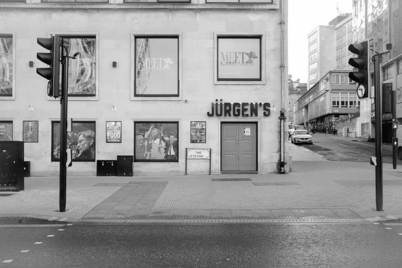 a black and white photo of a street corner, a photo, by Juergen von Huendeberg, adult video store, glasgow, theater, murals