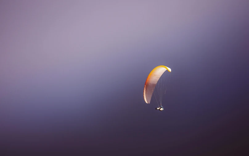 a person that is in the air with a parachute, a picture, by Eglon van der Neer, unsplash, postminimalism, gold and purple, medium format. soft light, firefly, gliding