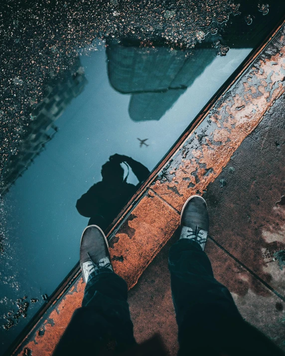 a person standing next to a puddle of water, down there, instagram post, streets, about to step on you