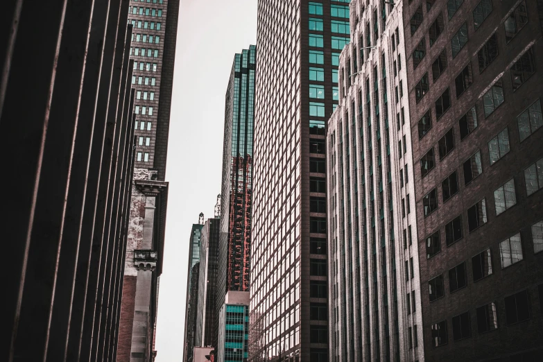 a city street filled with lots of tall buildings, a picture, pexels contest winner, hypermodernism, coloured photo, the building is a skyscraper, american city, buildings carved out of stone