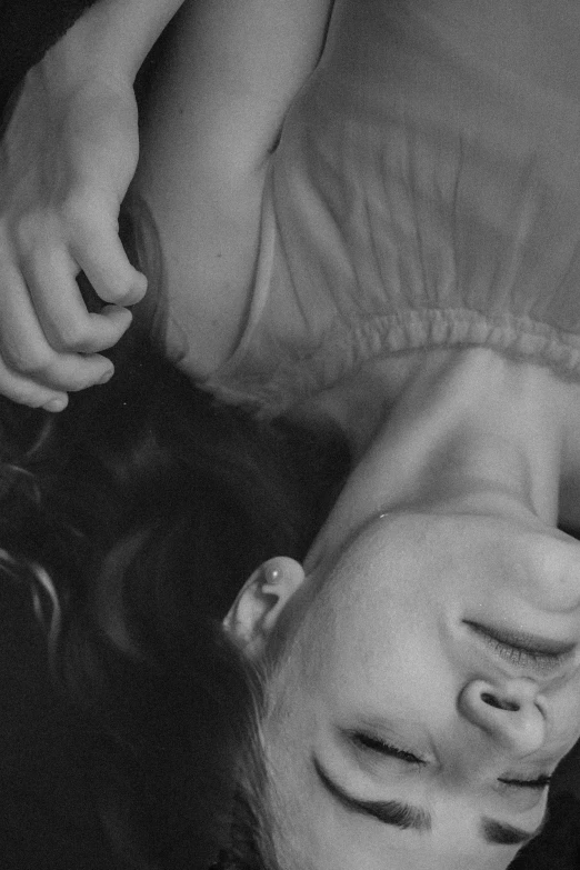 a black and white photo of a woman laying on a bed, inspired by Elsa Bleda, tumblr, hyperrealism, woman holding another woman, closeup of face melting in agony, smiling down from above, surrealisme aesthetic