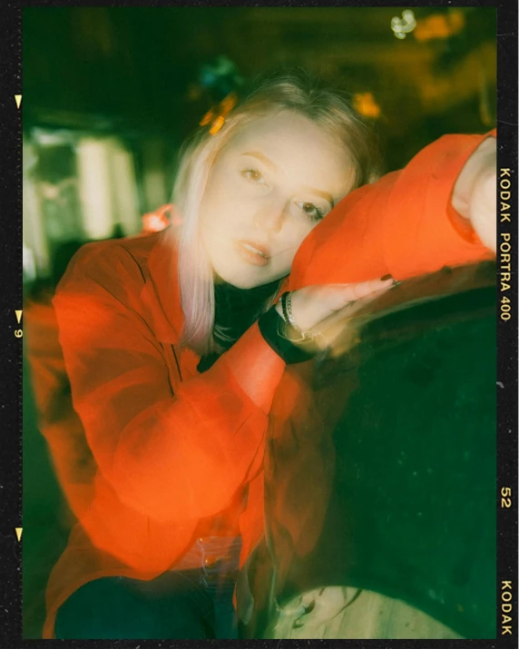 a woman leaning on the hood of a car, a polaroid photo, inspired by Elsa Bleda, unsplash, red and green lighting, portrait of kim petras, red and orange glow, wearing red jacket