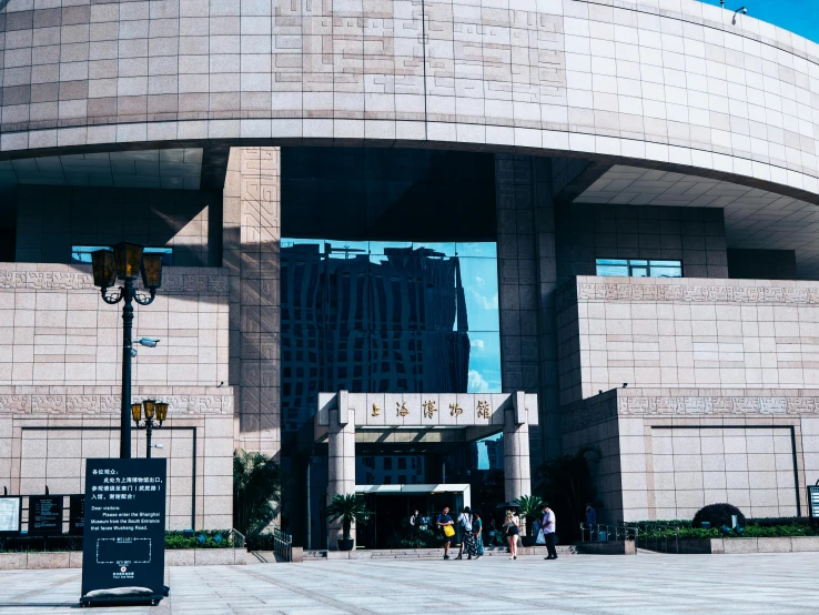 a group of people standing in front of a building, inspired by Zhang Shunzi, pexels contest winner, concert hall, research complex, entrance, on a bright day