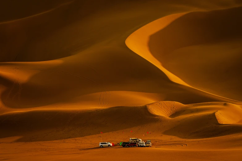 a couple of trucks that are in the sand, by Daniel Seghers, pexels contest winner, sahara, nat geo, dessert, distant photo