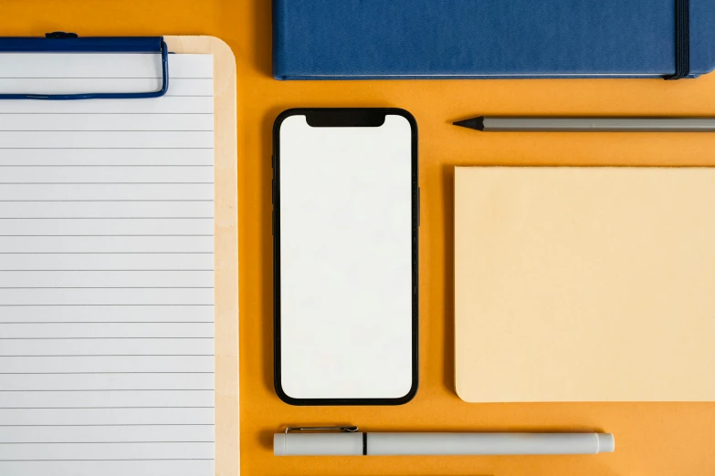 a cell phone sitting on top of a desk next to a notebook and pen, trending on pexels, postminimalism, square shapes, colors: yellow, hq 4k phone wallpaper, modern minimalist f 2 0