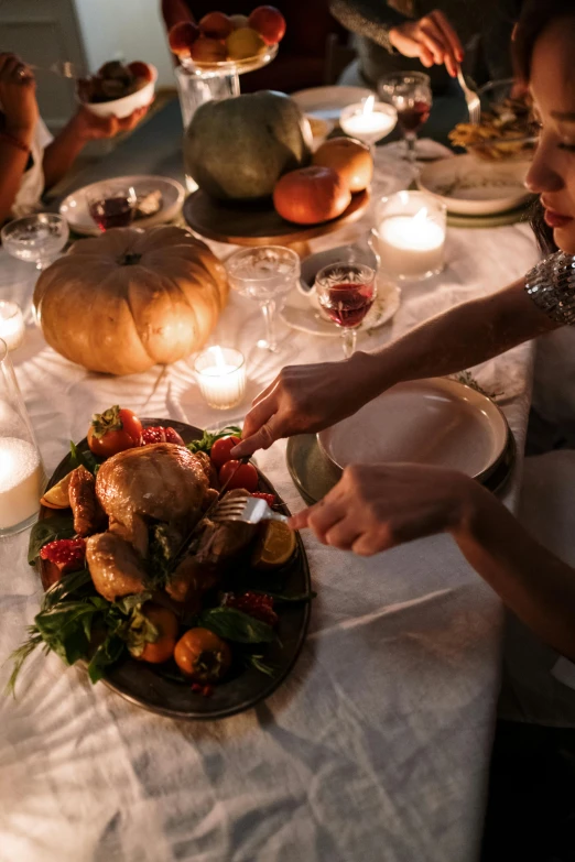 a group of people sitting around a dinner table, cornucopia, during the night