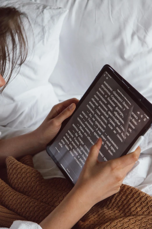 a woman reading a book on a bed, by Carey Morris, pexels, mobile learning app prototype, using a magical tablet, words, thumbnail