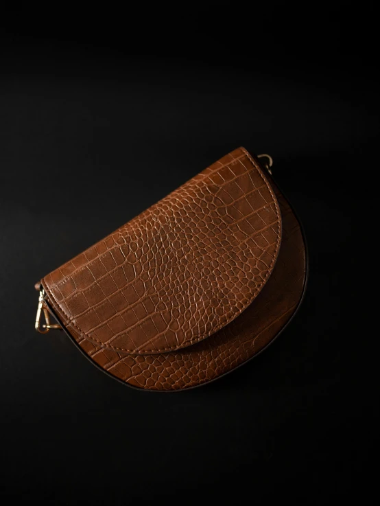 a brown purse sitting on top of a black surface, half moon, high quality product photography, thumbnail, curves