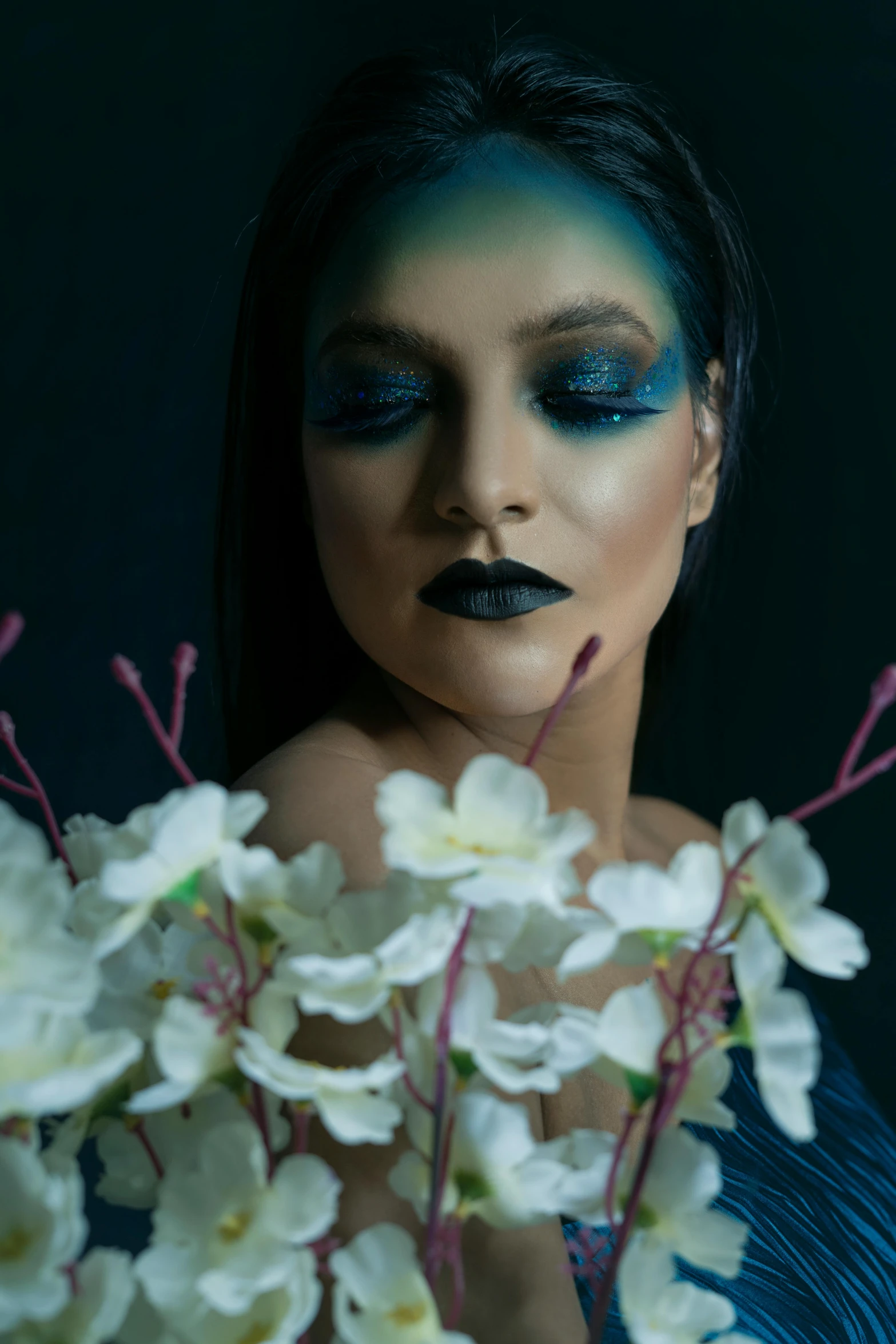 a woman in a blue dress holding a bouquet of flowers, an airbrush painting, inspired by Elsa Bleda, pexels contest winner, wearing goth makeup, dark green smokey eyeshadow, #trending, ariana grande photography