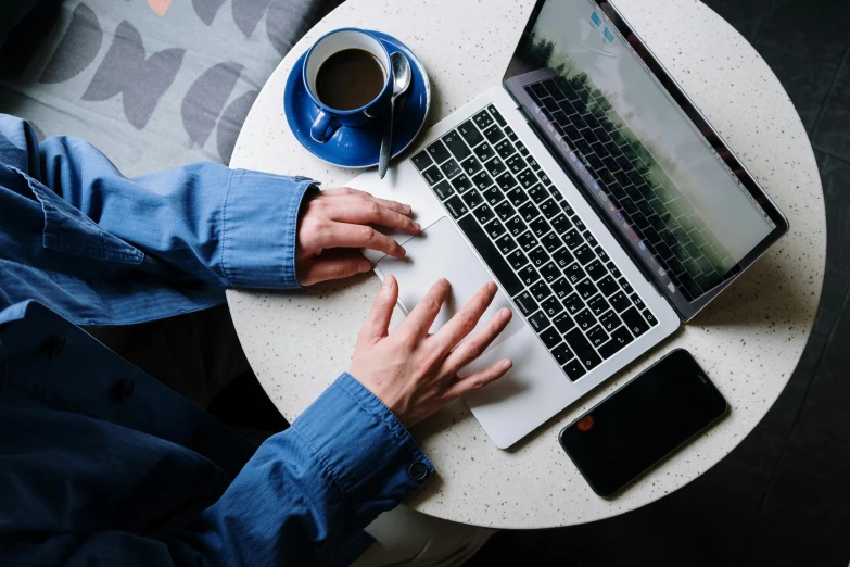 a man sitting at a table using a laptop computer, trending on pexels, bottom angle, worksafe. instagram photo, thumbnail, uploaded