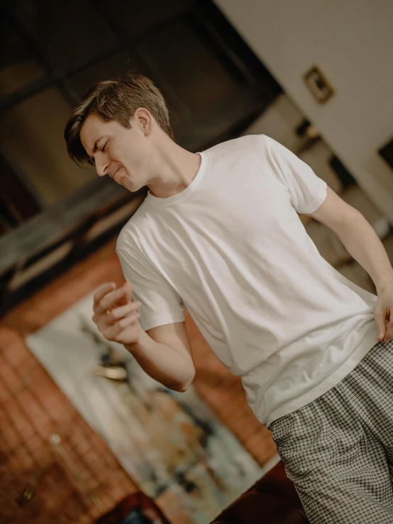 a man standing on a skateboard in a room, by Nina Hamnett, pexels contest winner, happening, wearing white pajamas, profile image, wearing a t-shirt, thumbnail