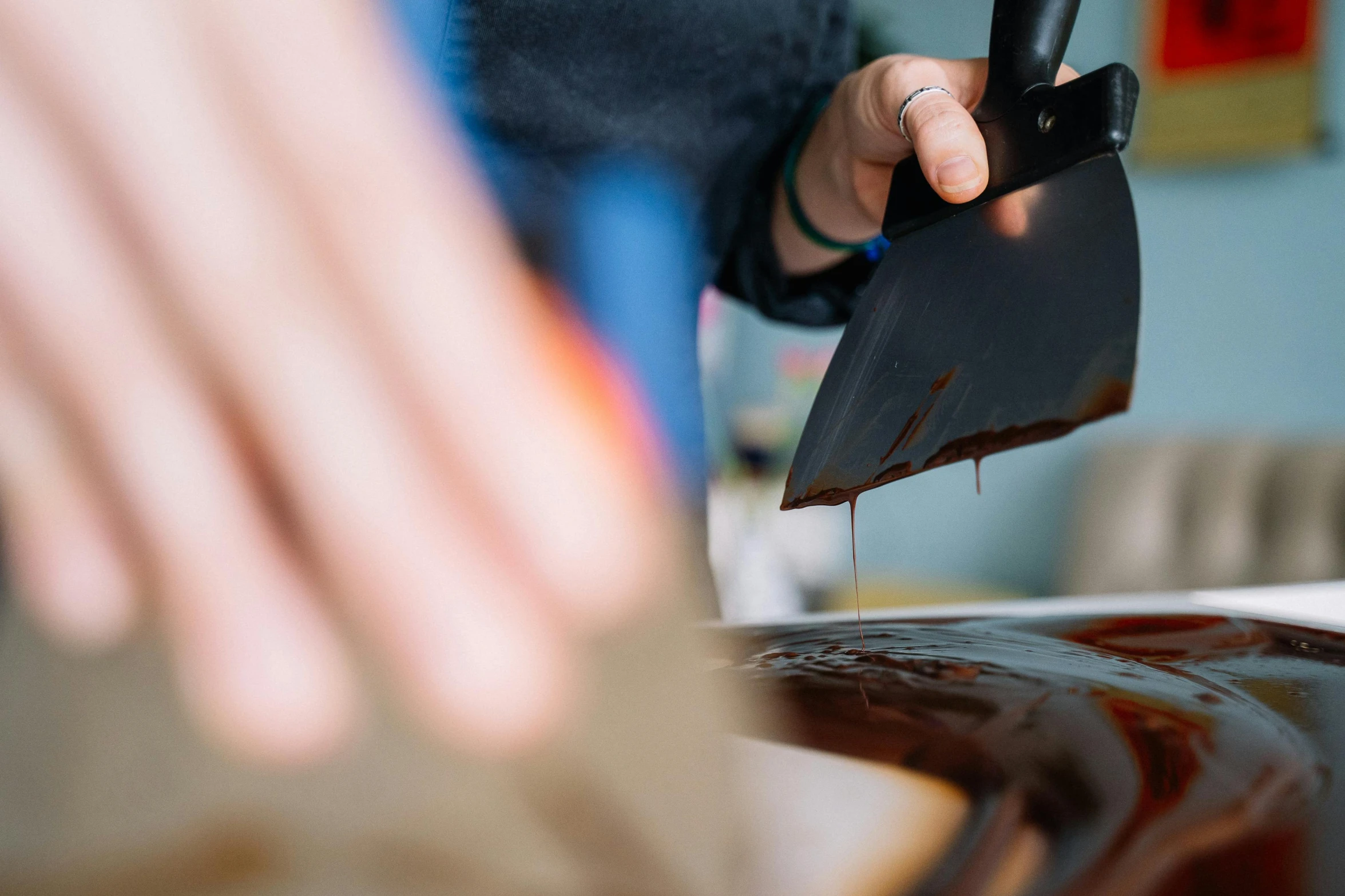 a person cutting a piece of chocolate with a knife, by Julia Pishtar, pexels contest winner, process art, varnished, closeup of a butcher working, heath clifford, gloss finish