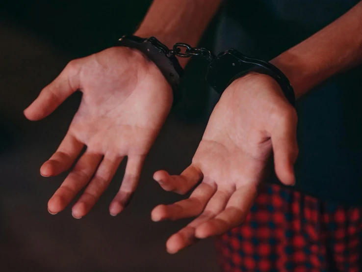 a close up of a person's hands with handcuffs, trending on pexels, 🎨🖌️, wrapped in leather straps, teenager, two male