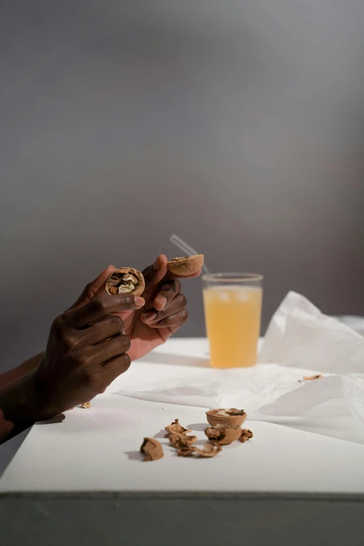 a person sitting at a table eating food, photorealism, walnuts, gloves and jewelry. motion, emmanuel shiru, holding syringe