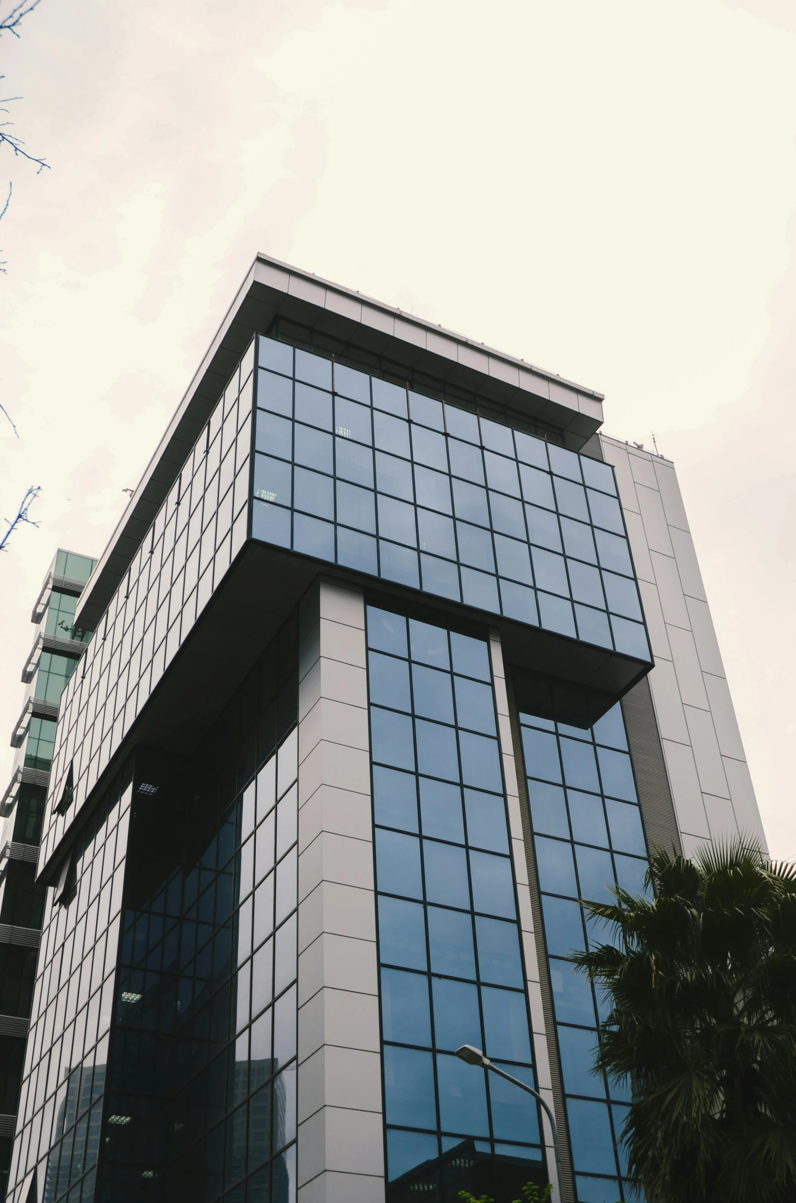 a very tall building with a lot of windows, unsplash, hurufiyya, low quality photo, clear glass wall, 90s photo, manila