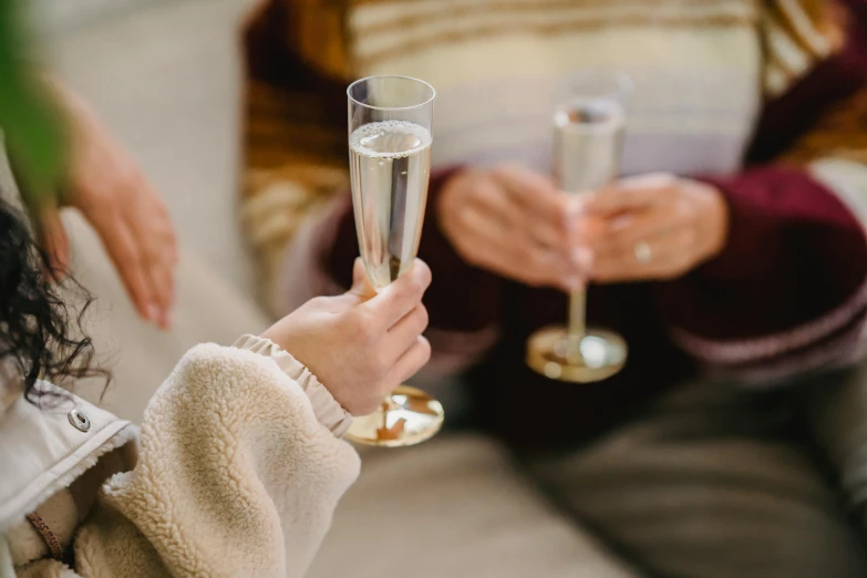 a close up of a person holding a glass of wine, champagne, cosy vibes, woman holding another woman, zoomed in