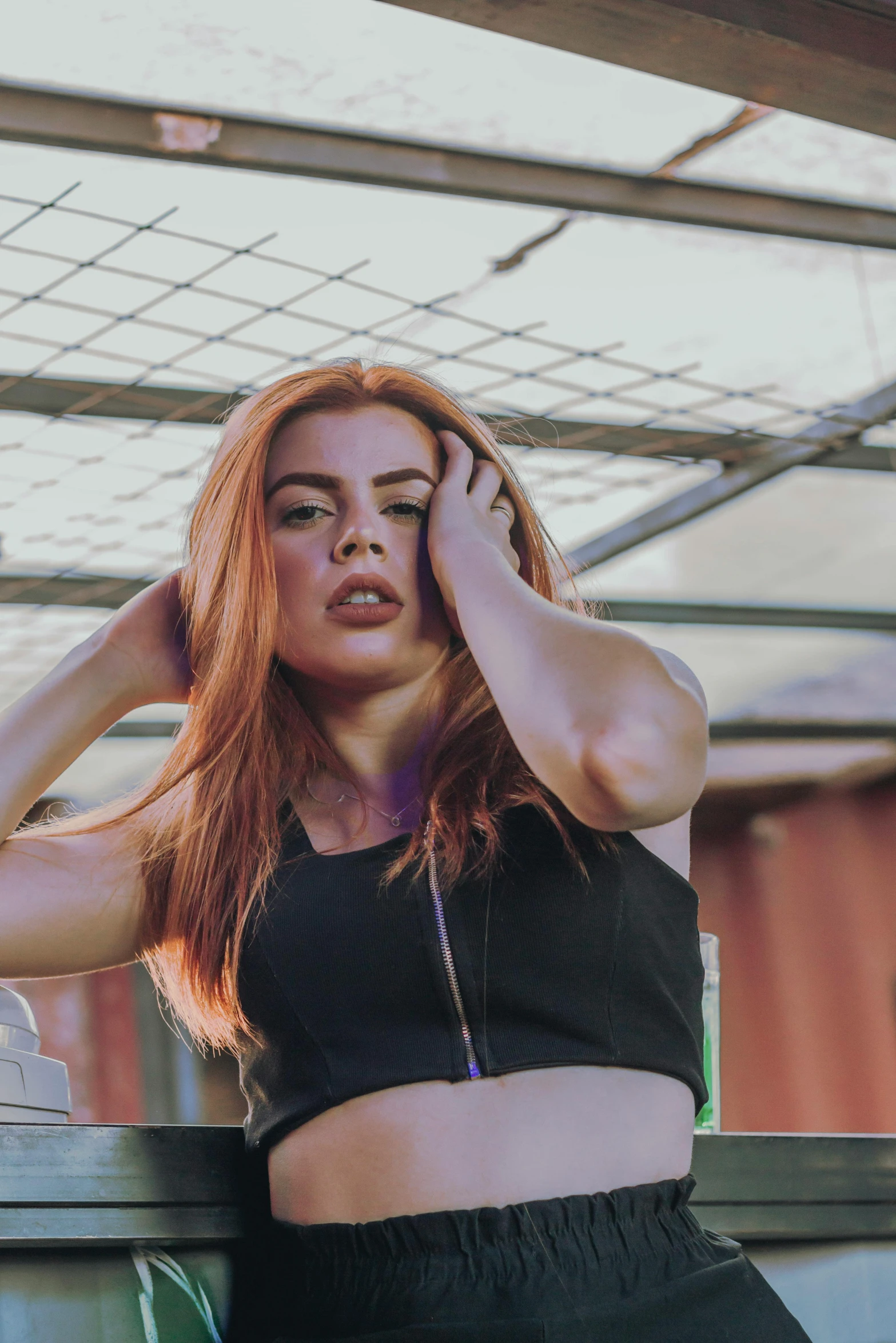 a woman sitting on top of a wooden bench, inspired by Elsa Bleda, pexels contest winner, renaissance, wearing a cropped black tank top, she has long redorange hair, charli xcx, gif