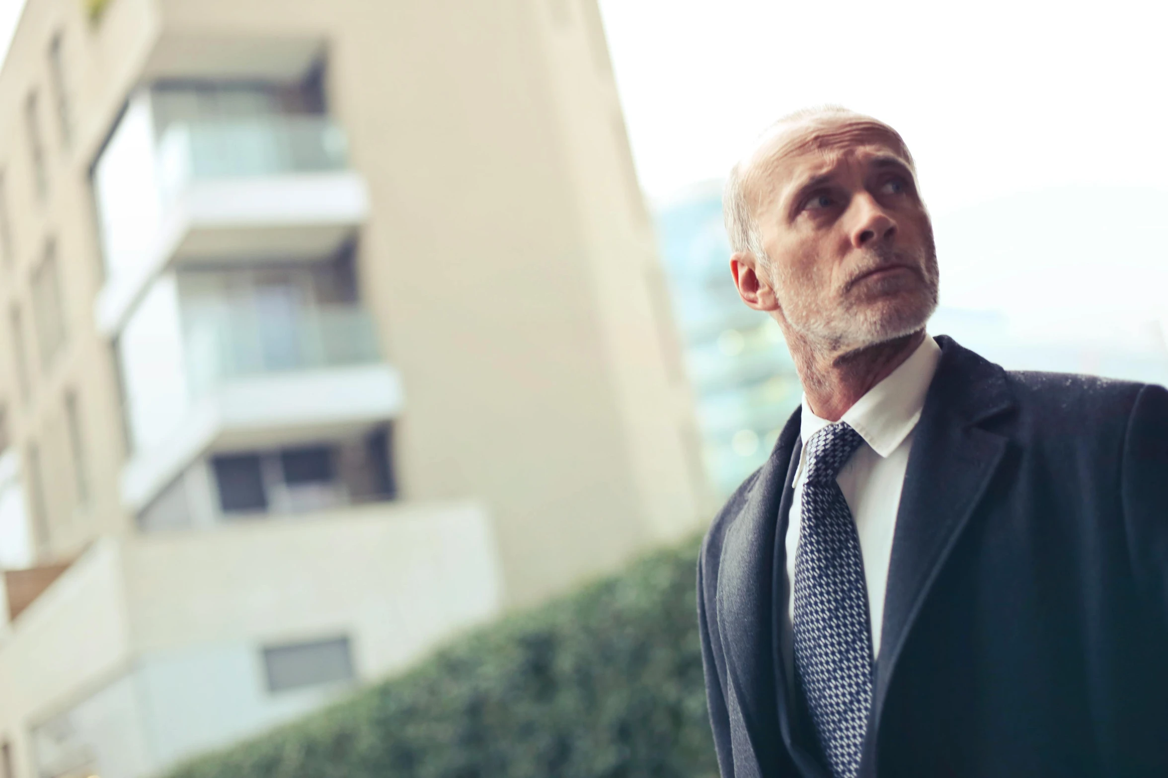 a man in a suit and tie standing in front of a building, pexels contest winner, renaissance, mike ehrmantraut, looking off into the distance, man walking, middle aged man