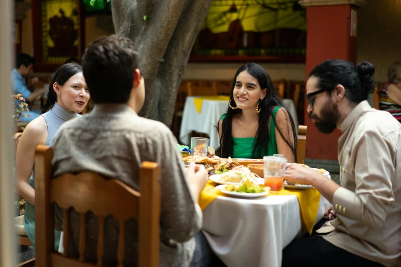 a group of people sitting around a table eating, lorena avarez, fan favorite, mexico, square