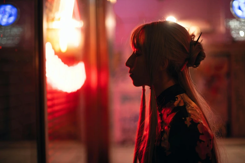 a woman standing in front of a window at night, inspired by Itō Shinsui, pexels contest winner, portrait of kim petras, tokyo izakaya scene, at gentle dawn red light, woman's profile