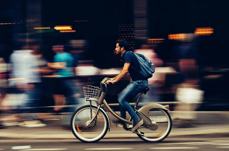 a man riding a bike on a city street, pexels contest winner, avatar image, vibration, ad image, slight blur
