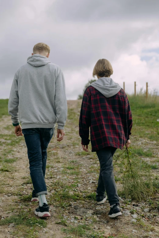 a couple of people walking down a dirt road, pexels, renaissance, male teenager, dardenne brothers, overlooking, non-binary