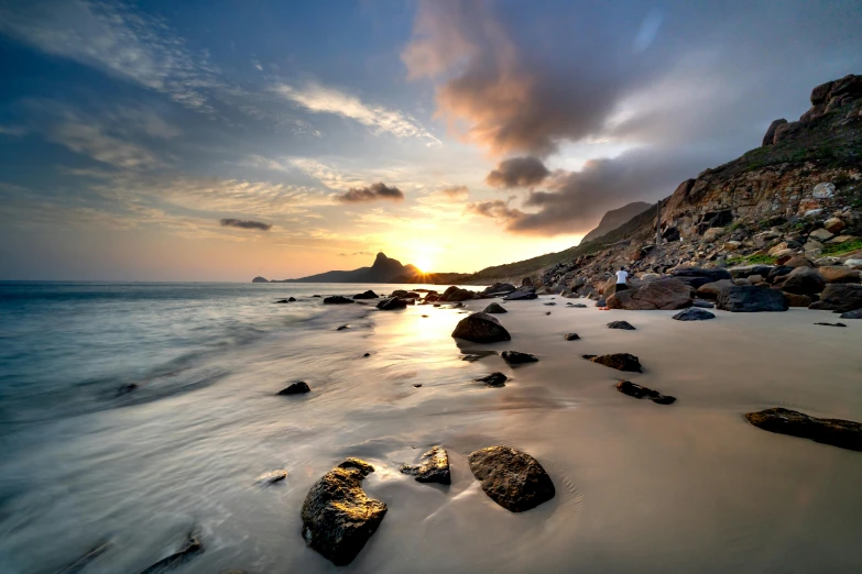 a couple of rocks sitting on top of a sandy beach, pexels contest winner, in socotra island, epic sunrise, thumbnail, 8 k -