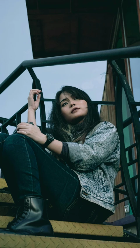 a woman sitting on the steps of a building, an album cover, inspired by Bernardino Mei, trending on pexels, realism, attractive girl tomboy, kuntilanak on tree, gray skin. grunge, chairlifts