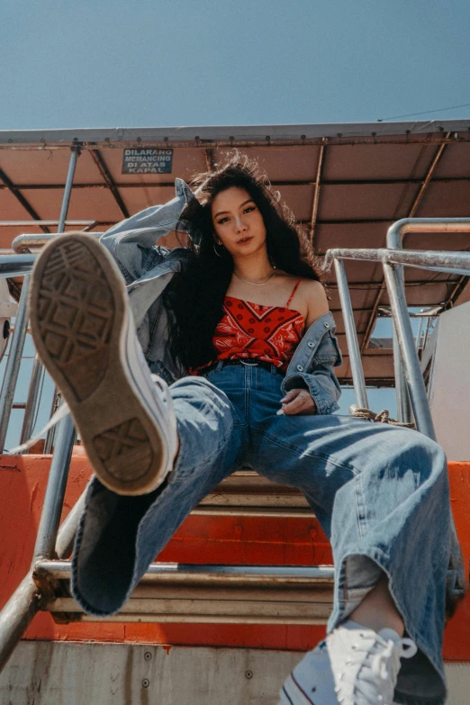 a woman sitting on top of a set of stairs, an album cover, trending on pexels, full body xianxia, ( ( ( wearing jeans ) ) ), promotional image, bella poarch