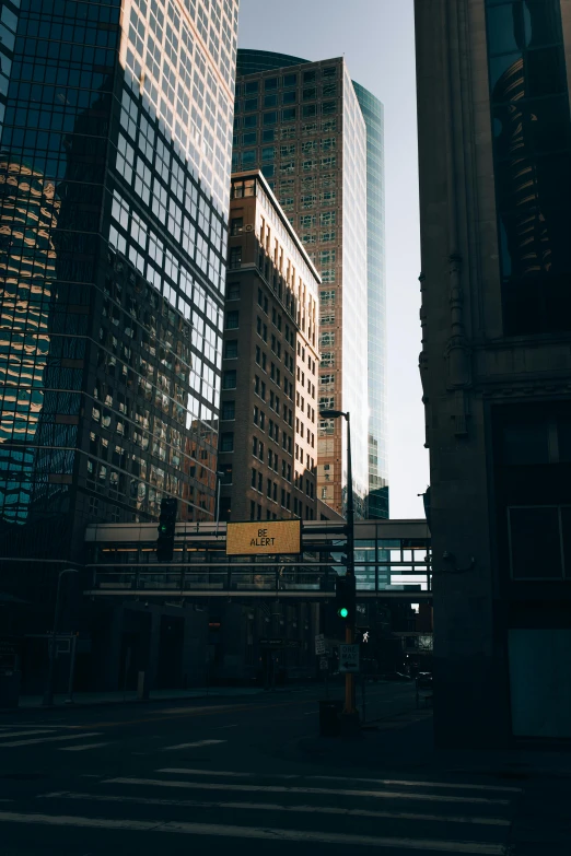 a city street filled with lots of tall buildings, by Andrew Domachowski, unsplash contest winner, modernism, very backlit, street signs, minneapolis, concrete jungle