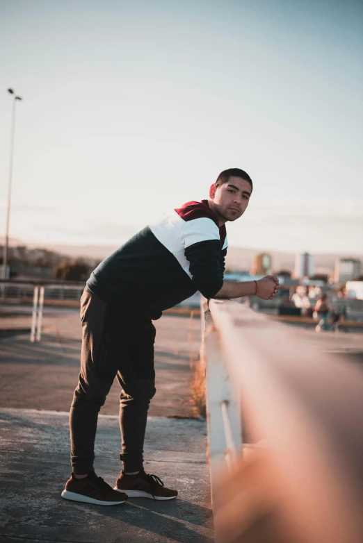 a man standing on a skateboard in a parking lot, pexels contest winner, happening, wearing a track suit, depressed dramatic bicep pose, standing on a bridge, hispanic