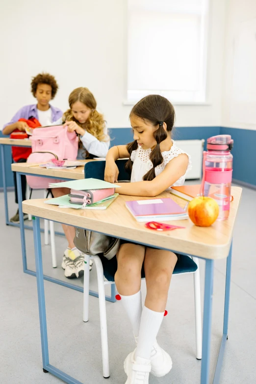 a group of children sitting at desks in a classroom, a picture, shutterstock, heidelberg school, multiple stories, promotional image, of a schoolgirl posing, school bag