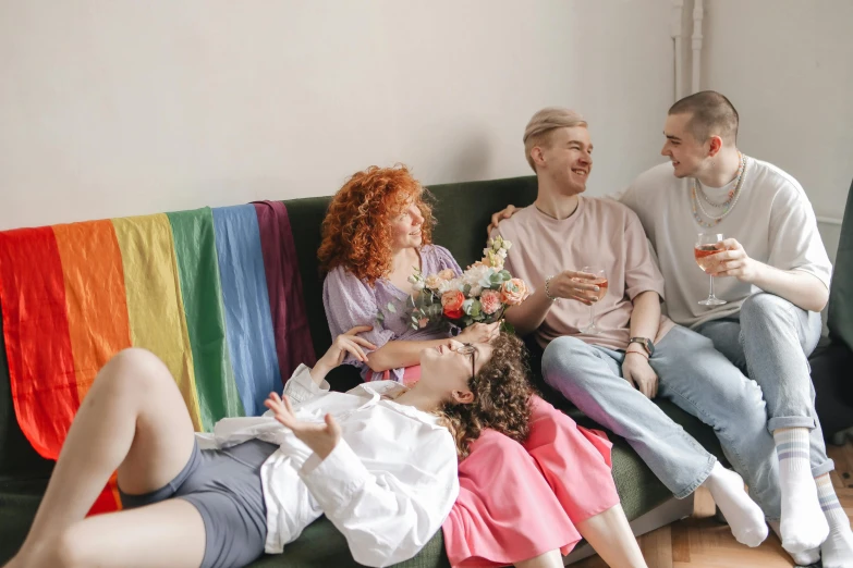 a group of people sitting on top of a couch, trending on pexels, renaissance, queer woman, rainbow clothes, flirting, pale - skinned