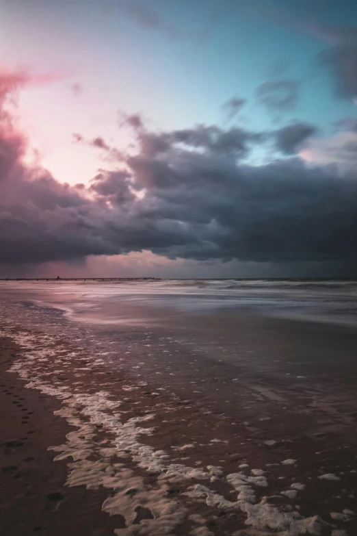 a person riding a surfboard on top of a sandy beach, pink storm clouds, paul barson, dark and foreboding, which shows a beach at sunset